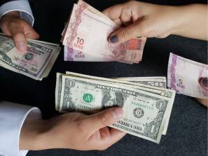Notas de real e dólar sendo trocadas